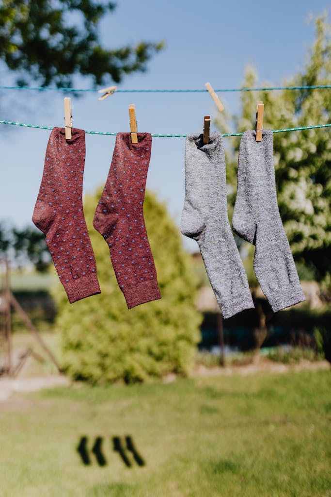 Vibrant socks hanging on a clothesline under a sunny sky, showcasing everyday life and hygiene.